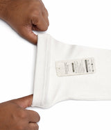 White sleeve extender with label held by a person's hands on a white background